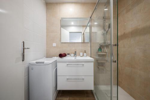 芒通ROCAMARE Piscine toit terrasse - Parking privée - Terrasse的浴室配有白色水槽和淋浴。
