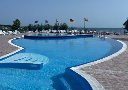 维耶斯泰拉吉尔拉村酒店的一个带蓝色水和白色椅子的游泳池