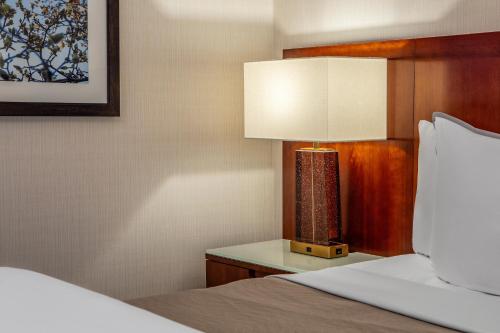 波士顿The Westin Boston Seaport District的一间卧室配有一张床和一张桌子上的台灯