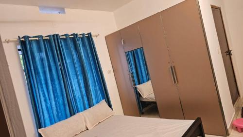 德里久尔Peaceful homes的一间卧室配有蓝色窗帘、镜子和床
