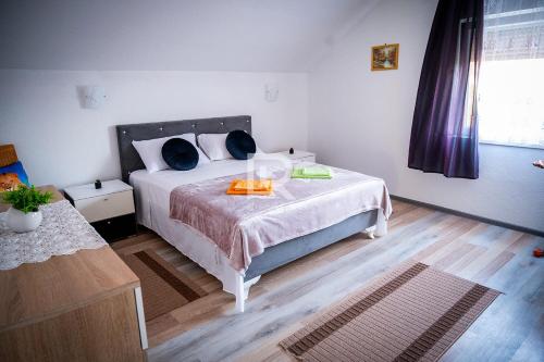 普里耶多尔Villa Dalmacija的一间卧室配有一张带白色床罩和蓝色枕头的床。