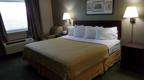 格尼Gurnee Motel的酒店客房配有一张带白色枕头的大床
