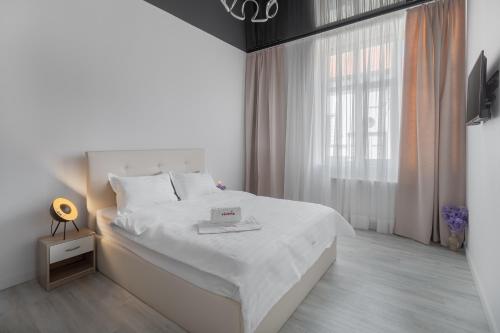 奥拉迪亚VIVERIA的白色的卧室设有白色的床和窗户。