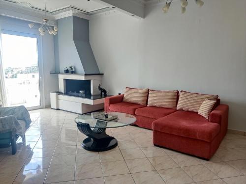 卡瓦拉Rafaela's Apartment的客厅配有红色的沙发和桌子