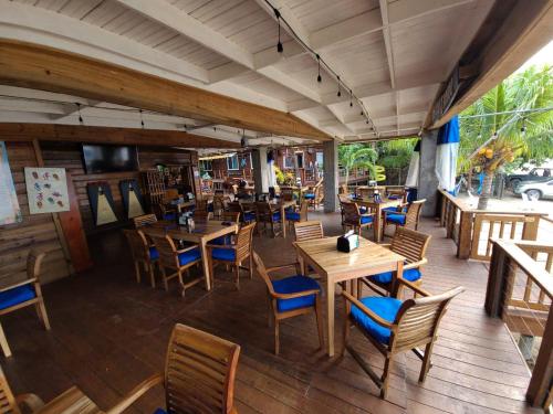 桑迪湾Blue Bahia Resort的一间空餐厅,配有木桌和椅子
