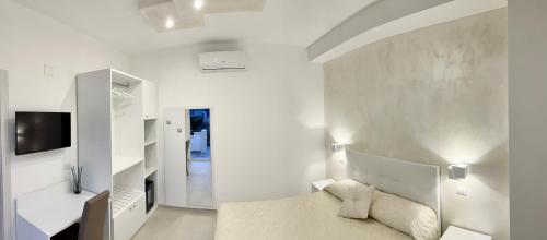 佩斯基奇Gemini Luxury Rooms的白色的客房配有床和电视。