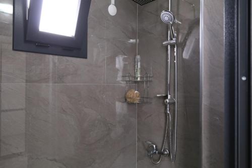 里泽Sama house的带淋浴的浴室和电视。