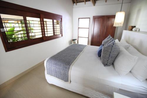 维拉港25号别墅的卧室配有带枕头的床铺和窗户。