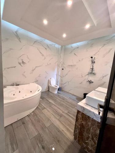 科托努Luxe Villa的带浴缸、卫生间和盥洗盆的浴室