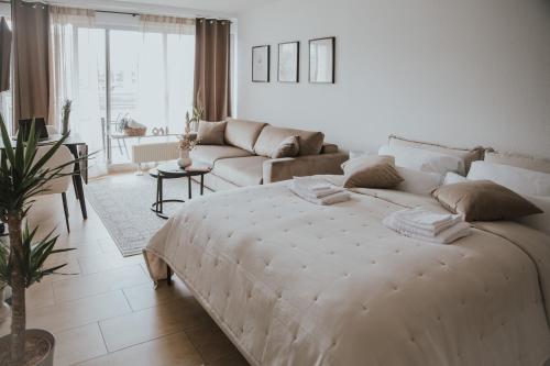 不莱梅Moderne Wohnung mit Weserblick und Uferpromenade的白色卧室设有一张大床和一张沙发