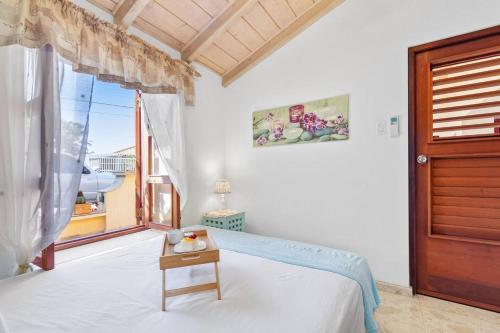 SavanetaVilla Laurence Aruban Oasis Footsteps To Ocean的一间卧室设有一张床、一个窗口和一张桌子