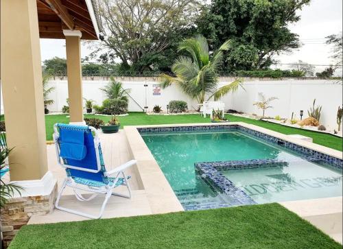 波特莫尔Gems Pool Side Chillax Stay的一个带游泳池和蓝椅的庭院