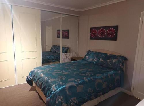 诺里奇3 bedrooms Sleeps 8 Self Catering House Near California Cliffs and Great Yarmouth Beach,Norfolk的一间卧室配有一张床和镜子