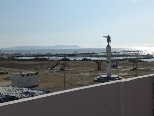 皮斯科Hospedaje Pariwana的一座有海滩的建筑顶部的一座男子雕像
