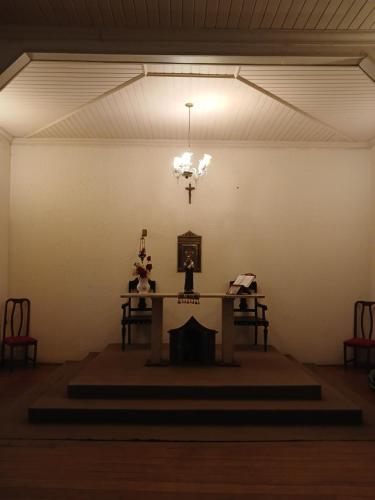 欧鲁普雷图Brumas Ouro Preto Hostel e Pousada的配有桌子和吊灯的房间