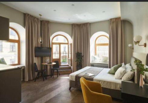 阿克套Royal Sea Resort的一间卧室配有一张床、一张桌子和两个窗户