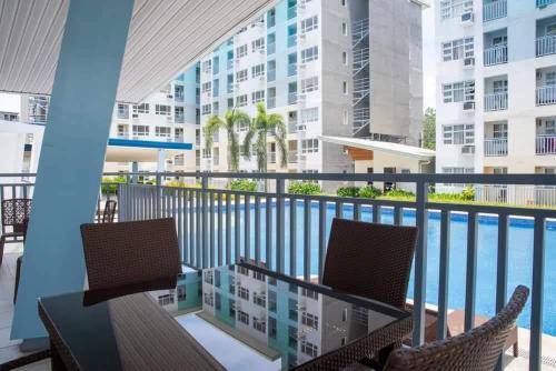 BabakScarlet Suites Condominium的一个带桌椅的阳台和一个游泳池