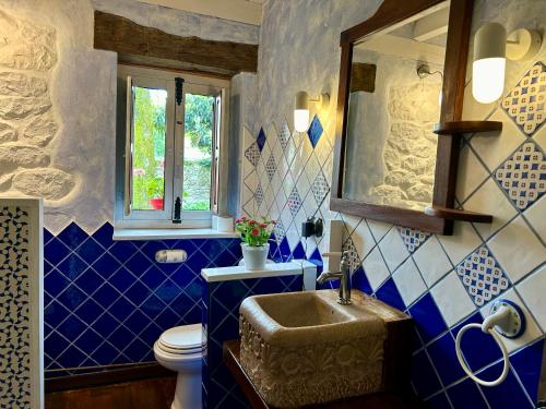 卡韦松·德·拉·萨尔Antaviana Cantabria的浴室拥有蓝色和白色的瓷砖墙壁和水槽