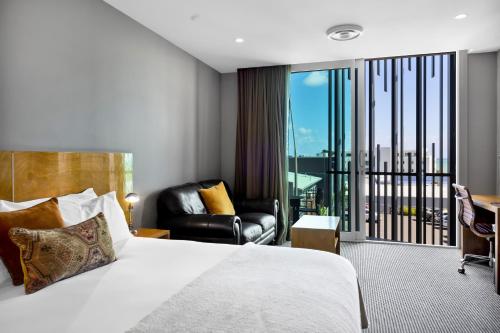 新普利茅斯国王和王后套房酒店的酒店客房设有一张床和一个阳台。