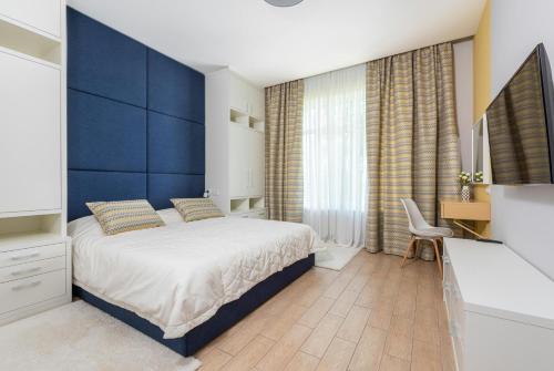新德里Hotel Aurora Mirage Delhi的一间卧室设有一张床和蓝色的墙壁