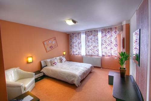 旧扎戈拉马尼尔家庭酒店的一间卧室配有一张床、一张沙发和一把椅子