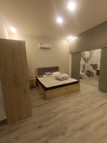Al QasţalVilla rotana airport road的一间卧室配有一张床,铺有木地板