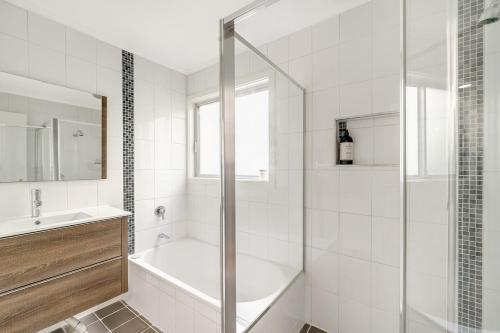图克雷Renovated Beach Home - Relax & Unwind的白色的浴室设有浴缸和水槽。