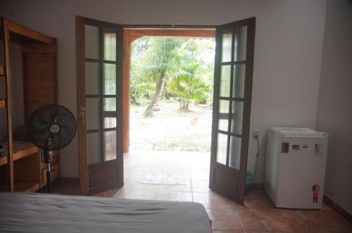 Sítio Peregrino das Estrelas的一间卧室设有一扇开放式门和一台冰箱