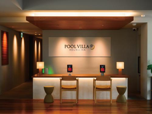 今归仁村Private condo Kourijima by Coldio Smart Resort的酒店大堂设有两把椅子,酒吧设有标志