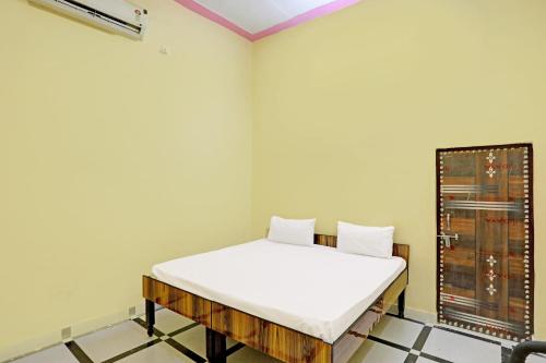 JhājharOYO J.M.D Restaurant &rooms的一间位于客房角落的带一张床的房间