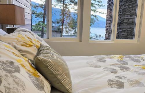 基洛纳Lake View Beach, Marina, Pool, HT的卧室内的一张床位,设有两个窗户