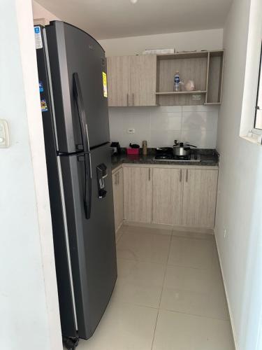 巴耶杜帕尔Mónaco的厨房配有黑色冰箱和木制橱柜。