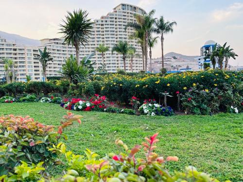 艾因苏赫纳Chalet in Porto Sokhna Beach Resort的一座种满鲜花和棕榈树的公园和一座大型建筑