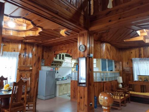 TudingCoziestCabin Guest House的一间带木墙和木制天花板的厨房