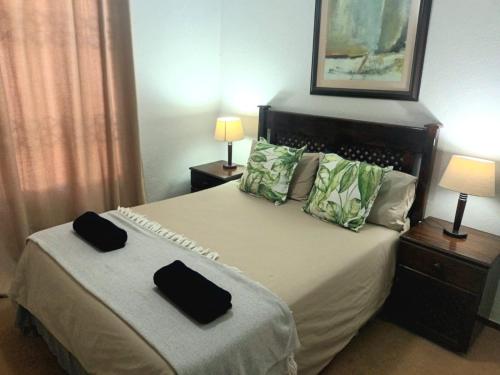 乌旺戈海滩Laguna la Crete 214的一间卧室配有一张带两个黑色钱包的床