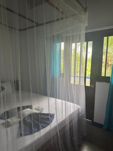本托塔Ayur Nelum Villa的卧室配有带白色蚊帐的床