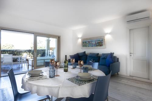 帕劳Sardinia Gold Luxury Apartment的一间带桌子和蓝色沙发的用餐室