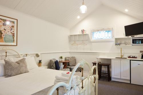 布赖特Tiffany's Cottages的一间白色卧室,配有床和厨房