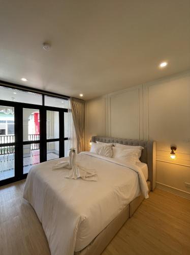 普吉镇Hawa House Phuket的一间卧室配有一张带白色床单的大床