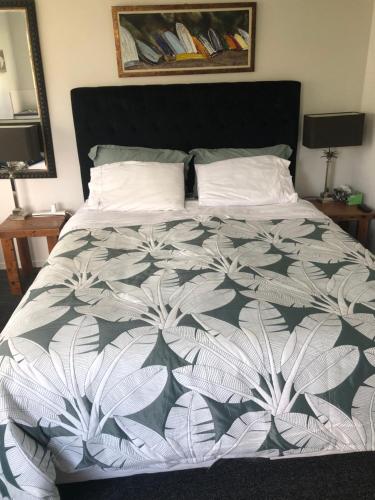 欧尼罗亚La Casita Waiheke的一间卧室配有一张带黑白色棉被的床