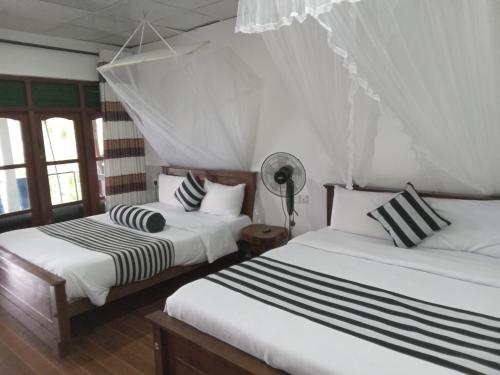 埃拉茶姆奥迪亚乡村民宿的配有2张床的白色墙壁和窗户客房