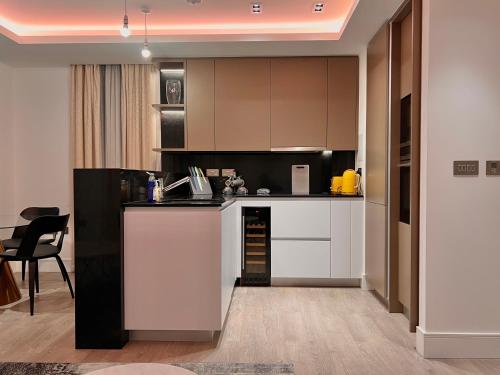 伦敦Luxury 2 Bedroom Apartment in Old Street, London的厨房配有白色和黑色橱柜和桌子