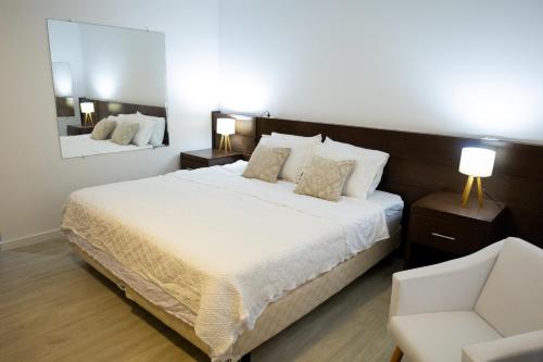 圣保罗Edifício Flat Hotel Congonhas的一间卧室配有一张大床和一把椅子