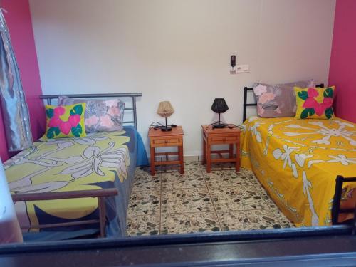 努库希瓦CHEZ ALIZHIA的一间设有两张床和两个床头柜的房间