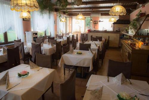CanzolinoAlbergo Aurora的餐厅配有桌椅和白色桌布