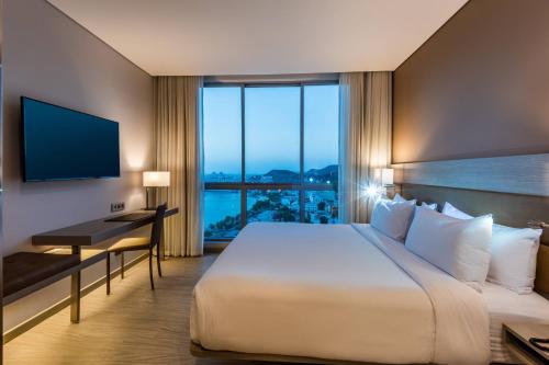 圣玛尔塔AC Hotel By Marriott Santa Marta的酒店客房设有一张大床和一张书桌。