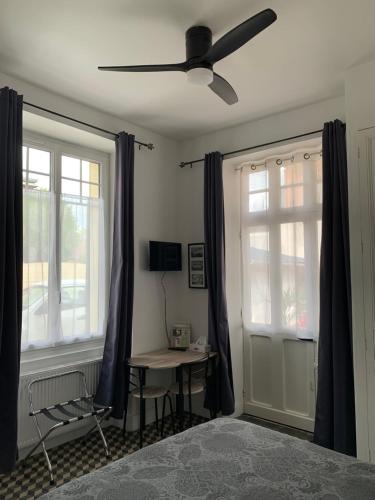 库谢韦尔尼Chez Chris的一间卧室配有吊扇、桌子和窗户。