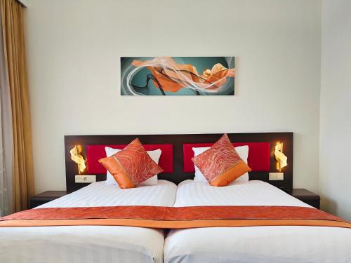 阿纳姆CN-Hotel的一间卧室配有一张带橙色枕头的大床