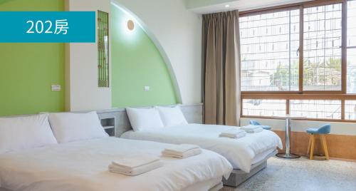 Dalin成都旅社民宿的配有窗户的酒店客房内的两张床