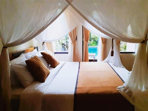德格拉朗杰桑村梅尔塔宾馆的卧室配有一张大白色床和窗户